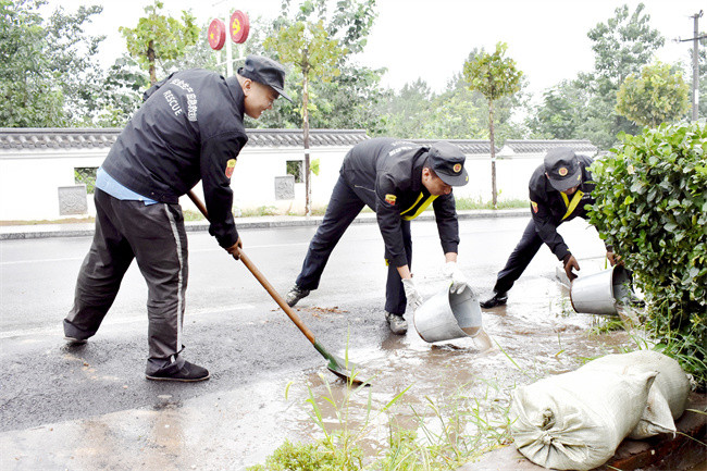 图为志愿队清理作业场周边积水.jpg